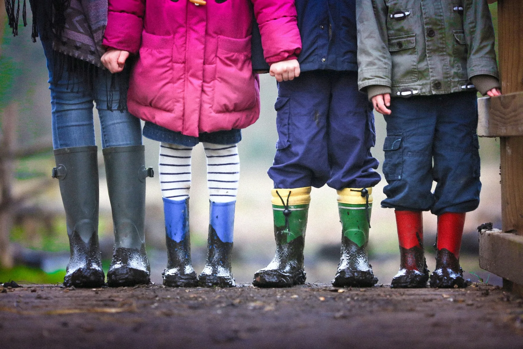 Children standing together in muddy wellington boots