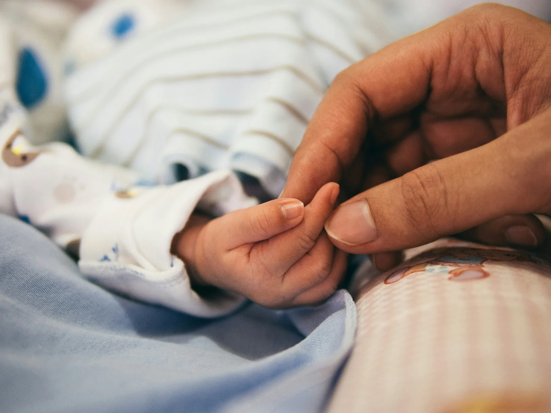New parent holding a swaddled newborn in a quiet room